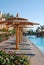 Plank beds under umbrellas at pool in hotel. Egypt