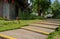 Plank-paved stairway in lawn before traditional buildings on sun