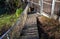 A plank walkway with stainless steel railings leads around the lake with rare ducks. the fence panel is made of rope fishing net.