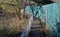 A plank walkway with stainless steel railings leads around the lake with rare ducks. the fence panel is made of rope fishing net.