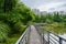 Planked footbridge with steel railings near lakeside at city in