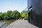 Planked path between modern building and pond in sunny summer