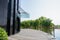 Planked path and verdant pond outside modern building in sunny s