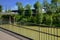 Planked steel footbridge before riverside glassed building in sunny summer afternoon