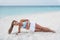 Planking exercise side plank with twist yoga fitness girl training obliques muscles for stomach toning on sunset beach
