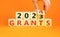 Planning 2024 grants new year symbol. Businessman turns a wooden cube and changes words Grants 2023 to Grants 2024. Beautiful
