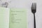 Plant-based diet green notebook with food category list with fork next to it