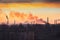 Plant or factory emissions seen above residential blocks of a city during sunrise or sunset. Environmental pollution. Panoramic