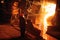 Plant for the production of steel. An electric melting furnace. Factory worker takes a sample for metal.