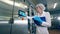 Plant worker checks a machine, typing on display. Female worker controls the quality of production equipment.