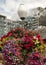 A plantar on a pole obscured by it`s brightly colored flowers of many types on Pier 55 in Seattle, Washington.