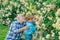 Planting flowers. Grandfather and grandson in beautiful garden. Gardener cutting flowers in his garden. His enjoys