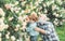 Planting flowers. Grandfather and grandson in beautiful garden. Gardener cutting flowers in his garden. His enjoys