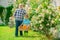 Planting flowers. Grandfather and grandson in beautiful garden. A grandfather and a toddler are working in flowers park.