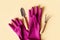 Planting tools set, pink gloves, shovel and rake flat lay on yellow background