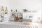 Plants and plush toy on shelves in scandi child`s bedroom interi