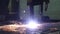 The plasma cutter in operation cuts with sparks a thick metal sheet into small parts at the factory