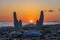 This plaster cast of two hands tries to catch the sun during this beautiful sunrise on the beach of Rethymno, Crete, Greece