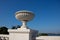 A plaster vase on a pedestal against the sky. Decorative element of architecture, close-up