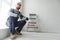 Plasterer in blue working uniform plastering the wall indoors