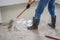 plasterer during floor covering works with self-levelling cement mortar, uses a needle roller