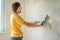 Plasterer home improvement handyman worker with putty knife working on apartment wall filling