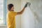 Plasterer home improvement handyman worker with putty knife working on apartment wall filling