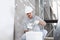 Plasterer man at work, take the mortar from the bucket to plastering the wall of interior construction site wear helmet and