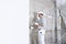 Plasterer man at work with trowel plastering the wall of interior construction site wear helmet and protective gloves, white wall