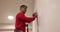 Plasterer smoothes wall with sandpaper on stepladder