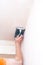 Plasterer smooths the walls with sandpaper close-up. Male hand of a worker. Stock photo