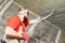 Plasterer using sprayer machine putting plaster mortar on ceiling