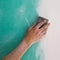 Plastering man hand sanding the plaste in drywall seam