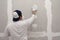 Plasterwork and wall painting preparation. Asian male applying filling drywall patch