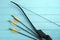 Plastic arrows and bow on turquoise wooden table. Archery sports equipment