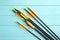 Plastic arrows on turquoise wooden table. Archery sports equipment