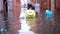 Plastic bags with garbage float on polluted flood water