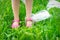 Plastic bags trash with children`s feet on green grass
