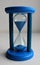 Plastic body of glass timeglass with blue sand pouring inside