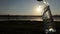 Plastic bottle with water is swayed on a lake bank at sunset in slo-mo