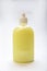 Plastic bottle of yellow antiseptic soap with dispenser on a white background