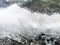 Plastic bottles and glasses on the sandy beach. Dirty water in which zllichny garbage floats. White foam on the shore