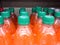Plastic bottles orange soda cases stacked in supermarket