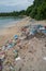 Plastic bottles and plastic bags and garbage at the beach near ocean at the tropical island