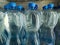 Plastic bottles with purified drinking water on shelf in fridge put up for sale shop