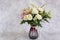 Plastic bouquet arranged in a beautiful shaped vase. marble background