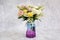 Plastic bouquet arranged in a beautiful shaped vase. marble background