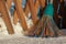 A plastic broom with multicolored bristles of the pile stands in the snow. The concept of cleaning the area of snow in the winter