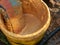 Plastic bucket with old bath puff, close up view. Bucket with golden paint on the ground. Vintage background. Old bast