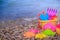Plastic children`s toys for sand on the background of the sea. Kids toys. Plastic sand toys. Bright toys. Sand construction.